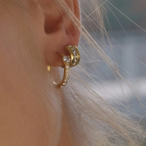 Elegant gold double hoop earrings with cubic zirconia stones worn by a model