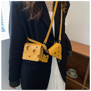 Detail of yellow cheese-shaped mini crossbody bag with PU leather accessories on a model