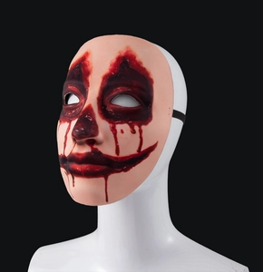 Detail of horror clown mask with blood stains on a 45-degree angle white model head