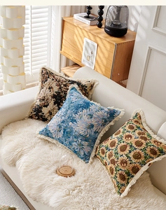 Details von Vintage-Leinenkissenbezügen mit Blumenmuster und Fransen auf dem Sofa