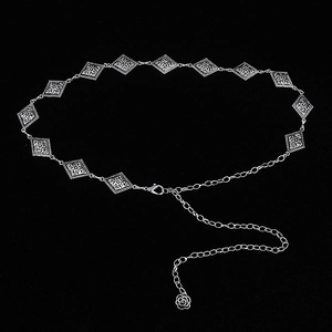 Detail of silver diamond-shaped metal belt with floral pattern and rose pendant extension