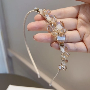 Exquisite handmade champagne crystal beaded headband with elegant pearl accents shown in hand