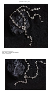 Detailed close-up of vintage silver rose link necklace on black stone texture background