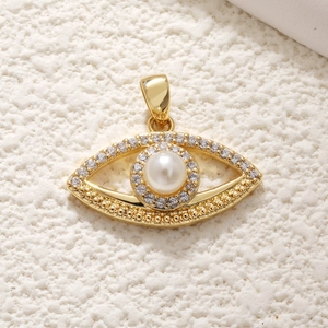 Golden Evil Eye pendant with central pearl and zircon accents on a textured background