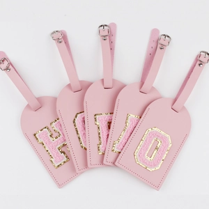 Pink PU leather luggage tags with glittery chenille letter patches spelling HELLO