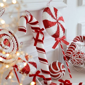 Red and white Christmas candy cane ornaments with glitter and velvet on white background