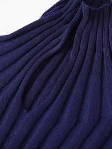 Nahaufnahme des lila Rippstrickpullovers zeigt feine Textur und vertikale Muster
