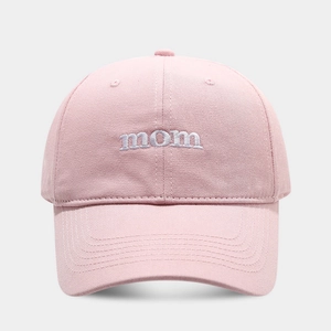 Detailed view of the white mom embroidery on a soft pink cotton baseball cap