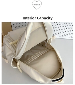 Detail view of the spacious inner compartment and functional pockets of the cream backpack