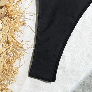 Detail of black bikini fabric showing high-elastic texture and durable double-needle stitching