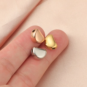 Polished stainless steel loose beads in gold, rose gold and silver on pink silk