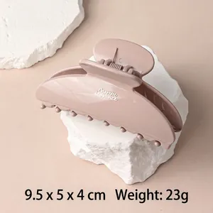Elegant lotus pink minimalist hair claw clip with glossy finish on stone display