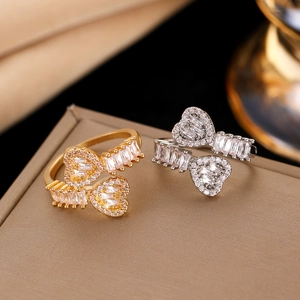 Macro detail of luxury double heart open ring featuring sparkling zircon inlay and gold plating