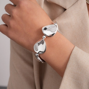 Detailed close-up of a silver minimalist organic pebble bracelet worn on the wrist