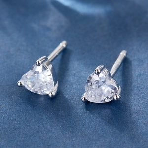 Macro shot of silver heart-shaped stud earrings with sparkling clear cubic zirconia