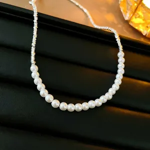 Collier élégant en perles baroques avec fragments argentés sur fond de cuir noir luxueux