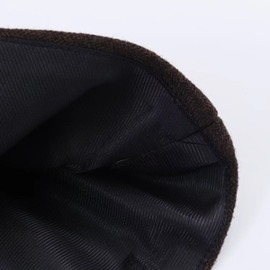 Close-up of the smooth black lining and dark brown coarse wool texture on coat detail