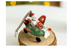 Close-up of a metal snowman pilot in a red airplane on a wooden base for Xmas decoration