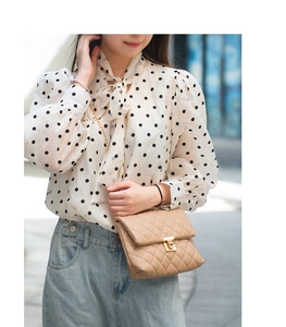 Close-up of elegant polka dot chiffon blouse with a stylish bow-tie neckline design