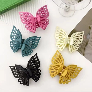 Close-up of butterfly hair claws in pink, blue, black, yellow, and beige matte colors