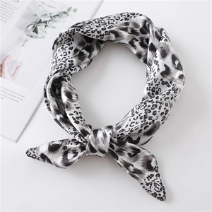 Leopard print satin neck scarf in black and white tones styled on a white surface