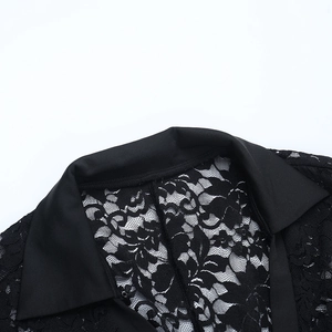 Detail of black lace polo collar showing sheer texture and delicate floral patterns
