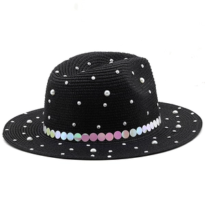 Detail of black straw fedora featuring white pearls, rhinestones, and iridescent sequins