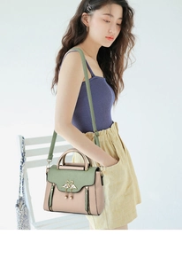Detail of pink and green PU leather crossbody bag with twin swan metal clasp and strap
