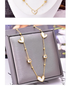 Detail of gold heart pendant necklace with white shell inserts and zircon pavé charms