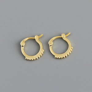 Close-up of gold circle earrings showing detailed bead accents and 925 silver hallmark