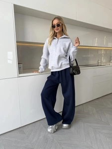 Detailed full-body view of grey half-zip sweatshirt and navy blue wide-leg trousers