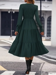 Elegant forest green long sleeve smocked dress with tiered skirt and elastic cuffs