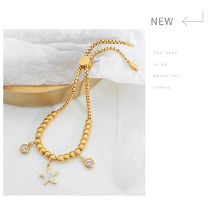 Detailed shot of adjustable gold beaded bracelet featuring a sparkling rhinestone starfish