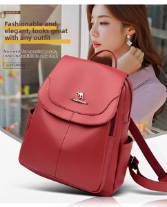 Detail of red pebbled leather backpack with a metal kangaroo logo and magnetic flap cover