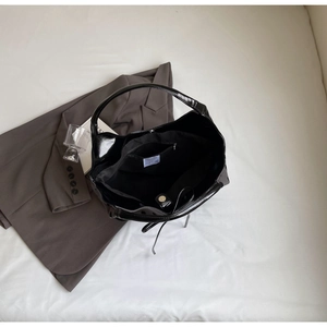 Interior view of black patent leather tote bag showing large capacity and inner pockets
