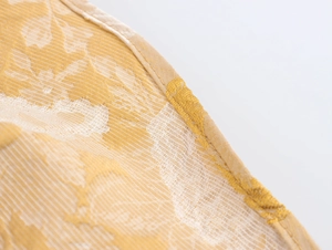 Nahaufnahme der gelb-weißen Jacquard-Stoffstruktur mit sauberen Saumdetails am Oberteil
