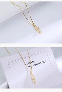 Detail of gold-plated bamboo pendant with cat eye stone and small crystal accents