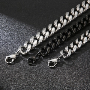 Close-up of polished silver and black titanium steel Cuban link chains with lobster clasps