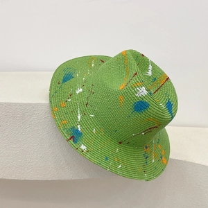 Detailed shot of green straw panama hat with colorful artistic spray graffiti design