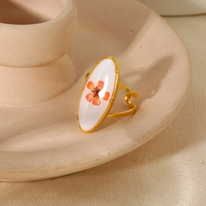 Detail of an 18K gold plated adjustable ring featuring a preserved orange dried flower