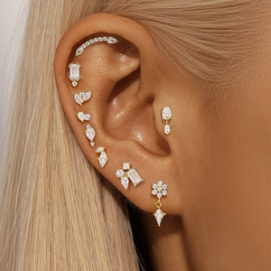 Gros plan sur un set de boucles d'oreilles dorées avec cristaux, fleurs et pendentifs