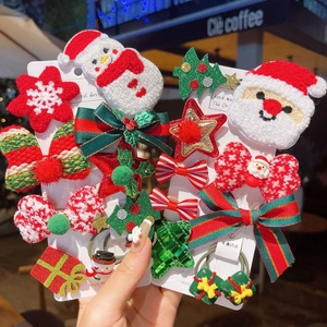 Detailopname van kerstman en kerstboom haarspelden met pluche texturen en strikjes