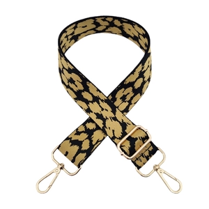 Detail of leopard print nylon shoulder strap with gold metal buckles on white background