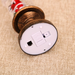 Detailed view of bronze Christmas lantern base with power switch and battery compartment