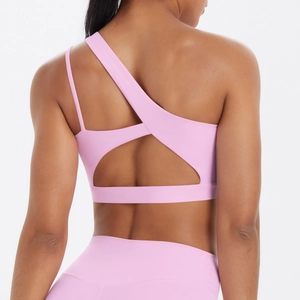 Macro detail of pink sports bra with asymmetric back straps and cutout design