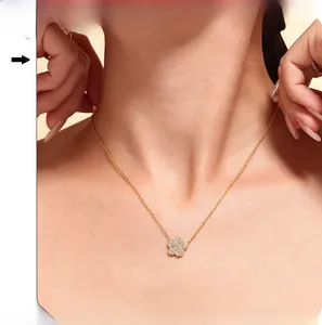Close-up of gold five-leaf clover pendant necklace with cubic zirconia on model neck