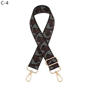 Detail of adjustable ethnic geometric pattern shoulder strap with gold metal hooks