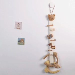 Hanging bear hair accessory organizer with clips and headbands on a clean wall