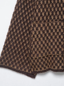 Detailaufnahme von braunem Strickstoff mit geometrischen Mustern und Wollstruktur