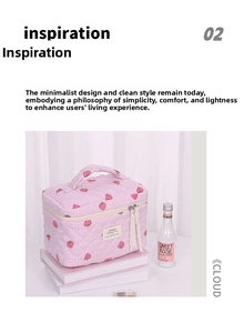 Detail of strawberry print quilted makeup bag showing top handle and dual zipper closure